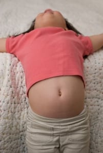 little kid lying on back with tummy exposed
