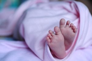 newborn baby's feet peeking out of blanket