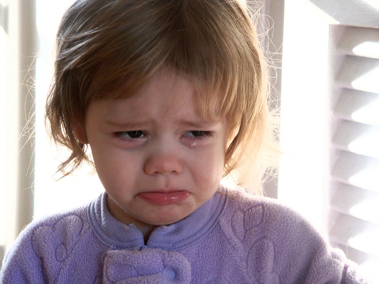 crying little girl in purple shirt