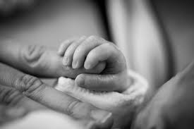 newborn's hand holding adult finger