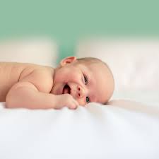 smiling baby lying on blanket